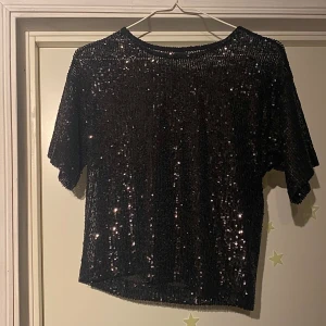 Svart glittrig festtopp - Super fin fest topp för exempelvis nyår eller annat. Säljer då den inte kommer till användning. Passar perfekt att ha en svart topp eller bh under. (Pris kan alltid diskuteras)