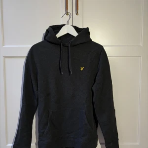 Lyle & Scott Hoodie - Säljer denna fina Lyle & Scott hoodie då den inte kommer till användning. Hoodien är i fint skick utan några defekter. Storlek M. Mörkgrå melange. Hör av er vid frågor eller funderingar!!