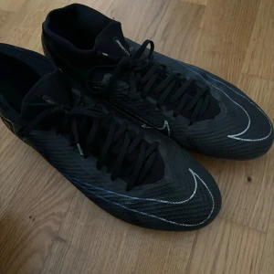 Fotbollsskor  - Det är ett par Nike Air Zoom Mercurial Vapor 15 Pro FG Shadow. Original pris: 1439 kr. Mitt pris: 599. Säljer dem för halva priset eftersom jag slutade fotboll och behöver inte dem längre. Skorna är i storlek 42,5 och är i bra skick.
