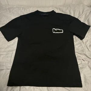Louis Vuitton T-shirt - Tröjan är i storlek S, den har aldirg använts 10/10 skick. Den sitter bra runt midjan men litte större i ärmana. Passar dig som  är runt 175 cm och uppåt hade jag nog sagt, beror på hur du vill att den ska sitta.