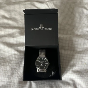 Jacques Lemans klocka  - Stilig klocka från Jacques Lemans i silver. Använd 7 gånger, skick 8/10 eftersom en liten rispa (se bild 2) Hör gärna av dig vid funderingar över klockan. 👍
