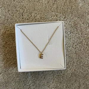 Bokstav halsband - Guld halsband med bokstaven ”E” på. Från Edblad 