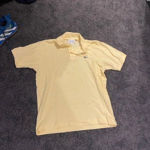 Ljusgul Lacoste piké  - Gul Lacoste piké, bra skick och normal i storleken