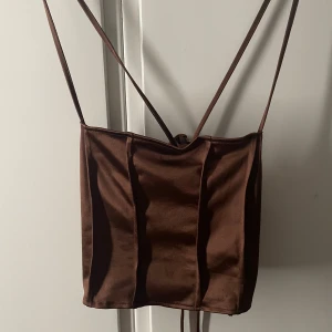 Brun satin topp med snörning på ryggen - Brun satin topp med snörning på ryggen fint skick 