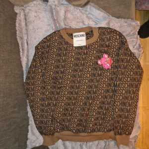 MOSCHINO COURTURE ULLTRÖJA, Strl M - MOSCHINO COURTURE tröja i ull, klassisk brun, strl M. Köpt för 1 år sedan, ej använd. I butik runt 4000kr. 
