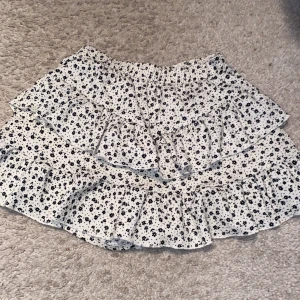 Volang kjol - Den är en volangkjol med shorts . Den är 146/152 cm från barnavdelning Zara kjolen har små svarta blommor på och är beige 