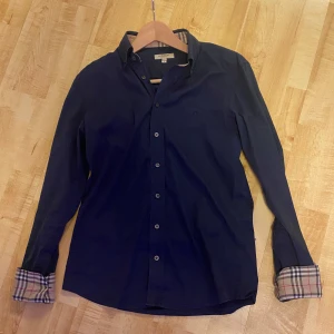 Burberry skjorta/S - Tja, säljer nu mina stilrena burberry skjorta då jag tyvärr inte använder den längre. Gott skick på den. Inga slitage eller märken. Passar dig mellan 170-180! Storlek S. Mitt pris-779! Fraktar spårbart via postnord!