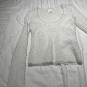 Luddig urringad tröja - Väldigt söt vit fluffig tröja med urringning från H&M. Använd ett fåtal gånger alltså fint skick.