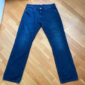 Levi's 559 jeans i mörkblå denim - Säljer ett par Levi's 559 jeans i mörkblå denim. De har en klassisk femficksdesign med dragkedja och knapp framtill. Jeansen är i bra skick och har en straight passform som är både bekväm och stilren. Perfekta för både vardag och fest!