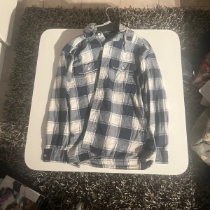 Rutig flanellskjorta med luva - Snygg och trendig flannelskjorta med luva från american eagle. Använd ett fåtal gånger.