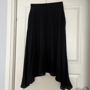 Svart långkjol storlek 36 - En jättefin svart medellång kjol från Kappahl. Välanvänd men i toppen skick. Kjolen har inte resår i midjan utan öppnas och stängs med dragkedja🌸🌸