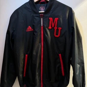 Manchester United jacka - En väldigt snygg Manchester United chinese new year jacka från 2021/22. Den är i nyskick, bara använd 1 gång. Jackan är för liten och därför säljer jag den. Orginal priset är 1100 kr och jackan går inte att köpa i butik längre. Priset kan diskuteras.