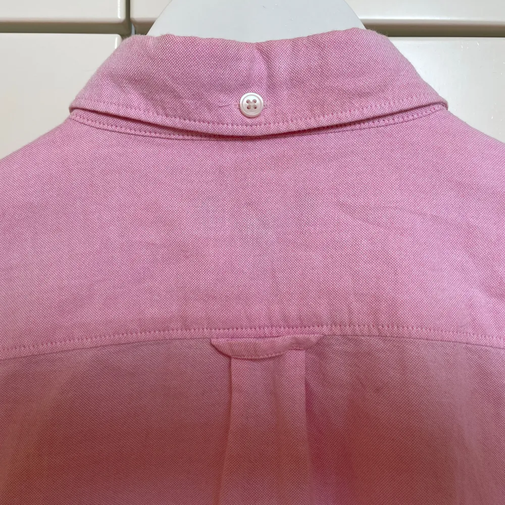 Säljer en klassisk rosa skjorta från GANT i storlek 158/164 cm. Skjortan är långärmad med button down krage med knappar. Den är i bomull och har en broderad logga på bröstet. Perfekt skick!. Skjortor.