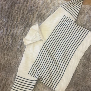 Vit och blå randig tröja från MNG - Säljer en superfin vit och blå randig tröja från MNG. Den har en dragkedja framtill och en hög krage som ger en snygg look. Perfekt för både vår och höst! Tröjan är i bra skick och passar perfekt till jeans eller kjol.