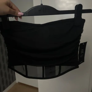 NA-KD - En festlig svart topp, passar perfekt till en utekväll. Den har en snygg detalj lite längre ner. Aldrig använt och har prislappen kvar, storlek S🖤