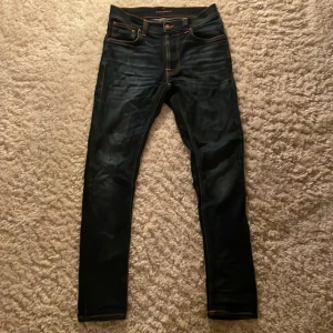 Nudie jeans - Säljer ett par snygga Nudie jeans som är storlek 27/30 men passar 30/30, jeansen är mörkblå, passformen är slimfit