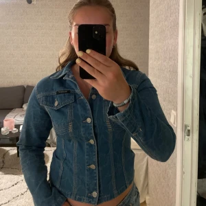 Jeansskjorta - Figursydd jeansskjorta i superbra skick! I storlek 38 men passar även 36:) Snyggt mönster och dekorativ detalj baktill.
