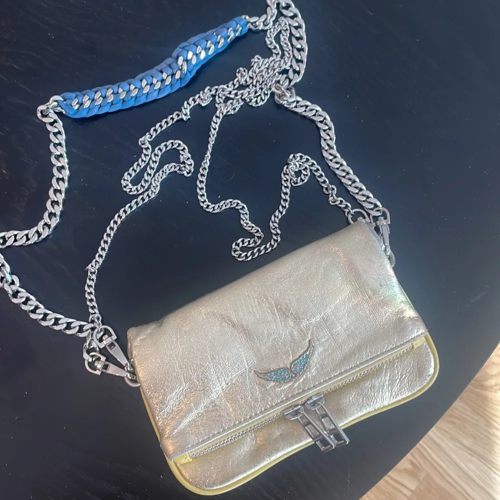 Super fin gulig liten Zadig väska men gula och blåa detaljer. Man får med två kedjor. 1 längre crossbody kedja och en kortare. Man kan även ta av båda banden och använda den som en clutch.   Väskan är i nyskick. . Väskor.