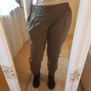 Bomullsbyxor med smock-resårer - Använda enstaka gång ~ Bekväma, mullvadsfärgade, med elastisk midja & benslut. Knappar & dragkedja i gylfen, två fickor. ~ STOR rensning i min shop ~ Välj 5 för 100kr oavsett pris, skicka medd/lämna som prisförslag (gäller där det står) ~