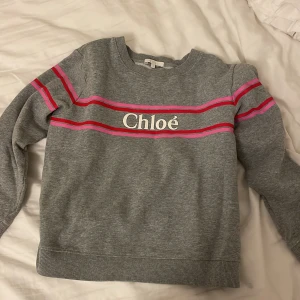 Chloé tröja - Säljer en grå Chloé tröja i storlek 12 år. Den är i väldigt bra skick och väldigt snygg!