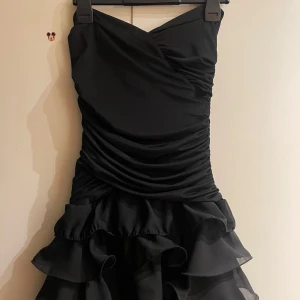 Svart kort off shoulder klänning - Jätte fin svart kort klänning. Off shoulder med ”plats på insidan för o hålla uppe den”. Helt ny aldrig använd. Inte min stil så tänkte sälja istället. Storlek S men passar M då den är stretchig. Pris kan diskuteras vid snabb affär! 