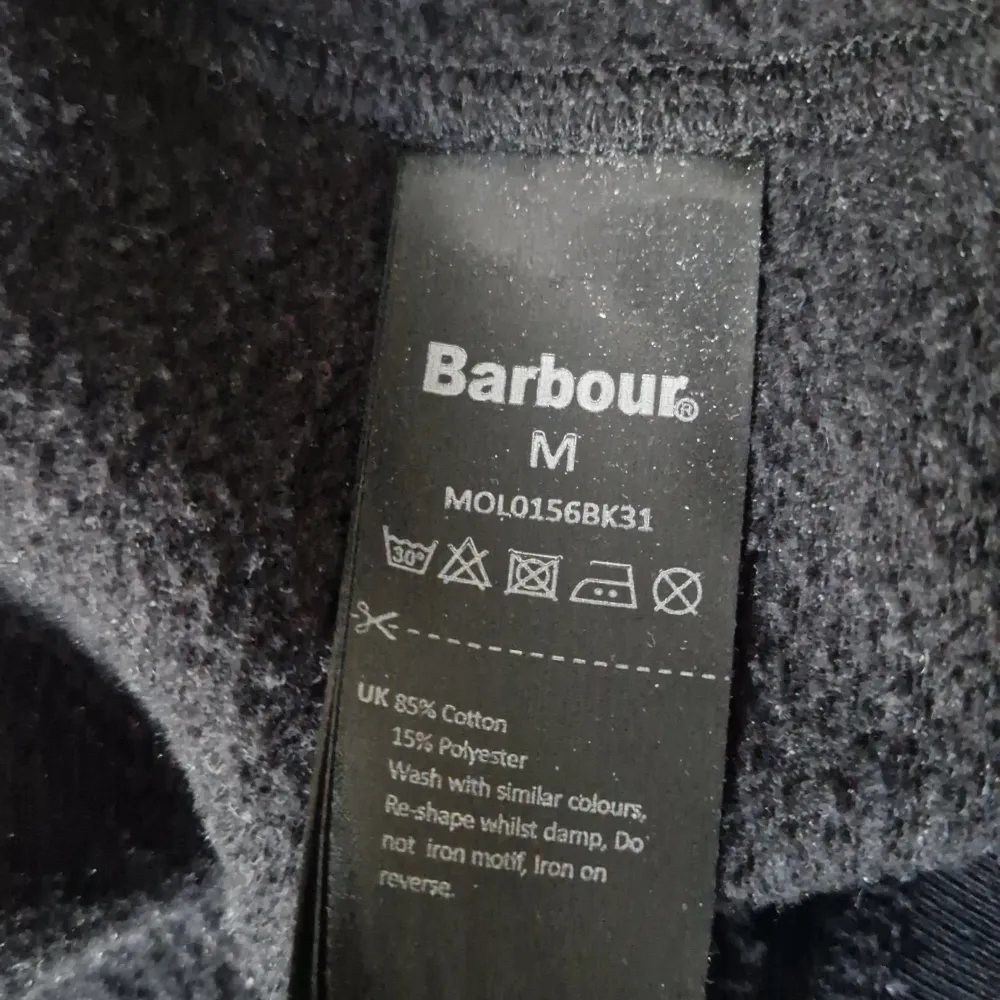 Säljer en snygg svart tröja från Barbour International. Den har ett coolt gult tryck på framsidan med märkesnamnet. Tröjan är i storlek M och är gjord av 85% bomull och 15% polyester, vilket gör den både bekväm och hållbar. Perfekt för en casual look!. Tröjor & Koftor.