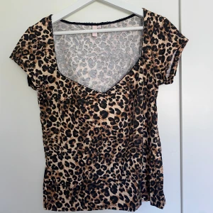 Leopardmönstrad topp med spetsdetaljer - Säljer den trendiga leopardmönstrade toppen. Toppen har en fin spetskant vid halsen som ger den en extra touch. Perfekt för vardag eller utekväll!!   Storlek: L/Xl men passar mer som L.                   ALDRIG ANVÄNT 