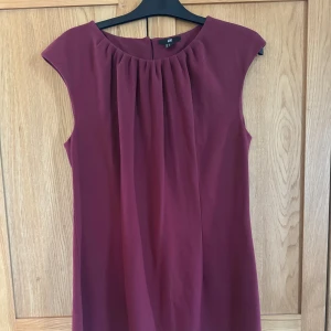 Fodralklänning - Vinröd fodralklänning från H&M. Längd ner till knäna med en liten slits där bak