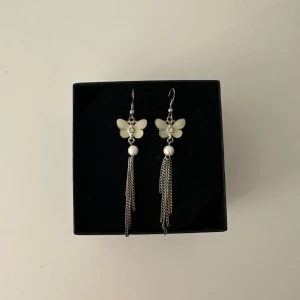 Örhängen  - Örhängen med fjärlil och pärla 