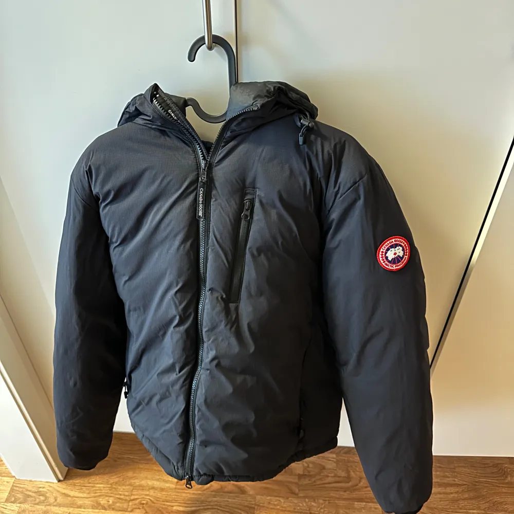 Säljer denna fina Canada Goose Lodge Hoody jacka. Jackan är 3-4 vintrar gammal, storlek M, kan funka på S, självklart äkta. Nypris ca 9000. Två små defekter, syns ej på avstånd (se bilder). Annars i fint skick. Skriv för autentisering eller frågor.. Jackor.