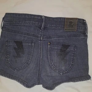Lowwaist Jeans shorts - Jeans shorts med blixtar på fickorna. Köpta second hand så vet inte märket. Bra kvalitet