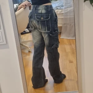 Jeans  - Ett par coola jeans med massa fickor.  Midjeomkrets: 80cm Innerbenslängd: 78cm