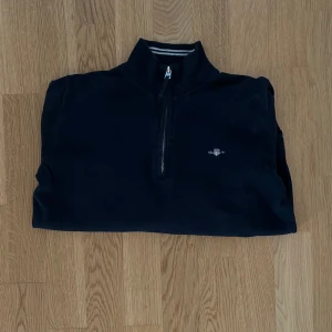 Gant Halv-zip - Hej! Jag säljer min Gant halv-zip eftersom att den har blivit liten på mig. Den har ett litet hål som knappt syns, se bild. Annars är den i bra skick. Hör av dig vid frågor. 