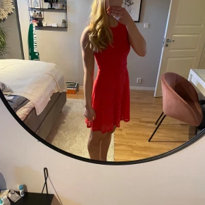 Röd spetsklänning från Dorothy Perkins - Snygg röd spetsklänning från Dorothy Perkins med en elegant design. Klänningen är ärmlös och har en vacker spetsdetalj över hela tyget. Använd 1 gång