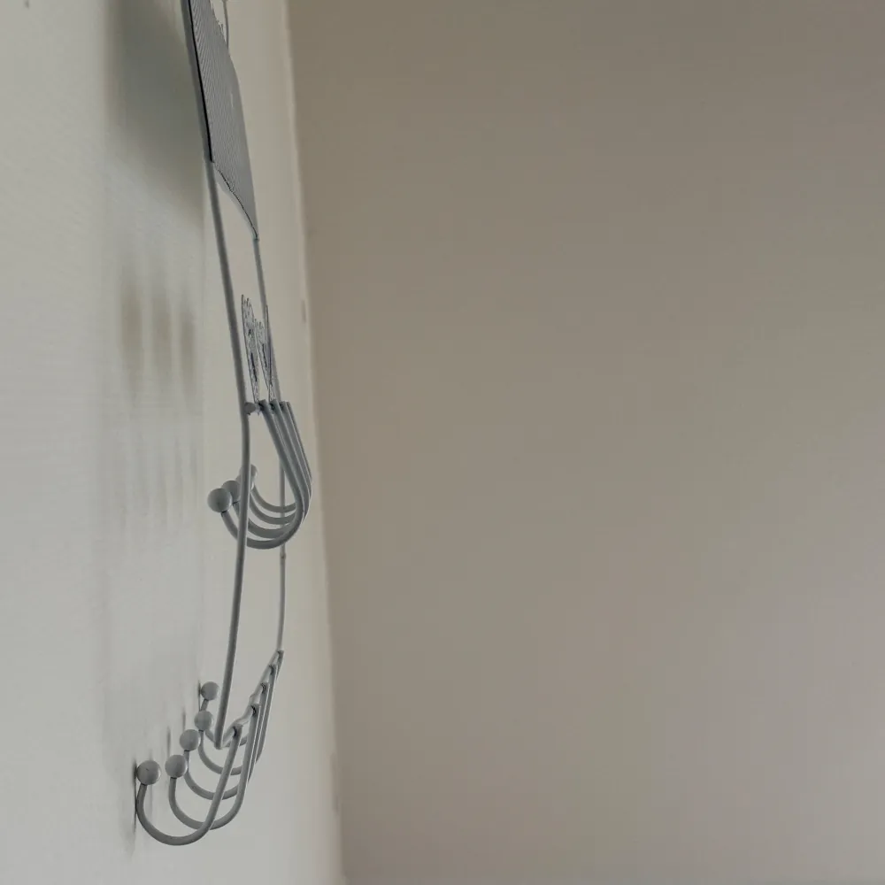 Charmig vit smyckeshängare med dekorativa hjärtan och flera krokar för att organisera dina smycken. Perfekt för att hänga upp halsband och armband. Hängaren har en fin, perforerad design upptill och ordet 'jewellery' i metalltråd.. Asusteet.