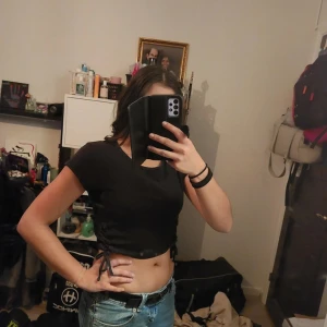 Svart croppad t-shirt - Säljer en svart croppad t-shirt med knytning i sidan. Perfekt för en avslappnad stil och passar bra till jeans eller kjol.