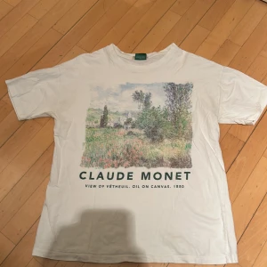 Vit t-shirt med Claude Monet-tryck från Pull&Bear - Vit t-shirt från Pull&Bear med ett vackert tryck av Claude Monets målning. Tröjan är i storlek M. Va inte rädd för att ställa frågor. 
