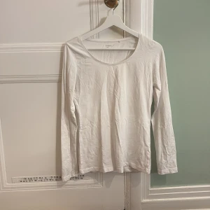 Vit långärmad topp från Lindex - Säljer en enkel och stilren vit långärmad topp från Lindex. Perfekt basplagg med rund halsringning, tillverkad i mjukt material för bekväm passform. Passar utmärkt till lager-på-lager eller som den är.