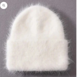 Vit mössa Boun - Mysig vit stickad mössa perfekt för kyliga dagar. Den har en enkel design med ribbad kant som ger en skön passform. Ett måste för vintern!