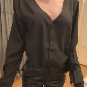 Svart blus med knappar - Skjorta/blus från lager 157 i storlek xs/s. Snörning i midjan som går att dra åt 
