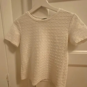 Vit stickad topp - Säljer en vit stickad topp med korta ärmar och ett subtilt vågmönster. Pris kan diskuteras!