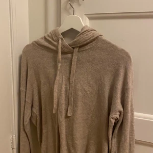 Beige hoodie från GAP - Mysig beige hoodie från GAP i storlek XS. Perfekt för kyliga dagar med sin mjuka och bekväma design. Den har en klassisk huva med knytband och långa ärmar.