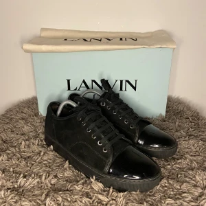 Lanvin Toe Cap - Snygga svarta sneakers från Lanvin med en stilren design. Skorna har en blank tå och snörning framtill. Perfekta för en elegant och modern look. Uk 7 passar 41-43, är i näst intill nyskick! Endast skorna ingår. Hör gärna av er vid flera frågor eller funderingar!💯🌟