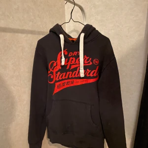 Svart hoddie från superdry. - Snygg svart hoddie från märket superdry säljes. Tröjan har inga defekter och är sparsamt använd. Priset är inte hugget i sten och om ni har fler frågor är det bara att skriva 🙌🙌