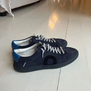 Mörkblå sneakers med mockadetaljer - Snygga mörkblå sneakers från Oliver Cabell. Använda ett par gånger. Har haft en extra sula så därför är dom original lite smutsiga 