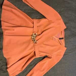 Finklädd tröja  - Snygg korall/rosa färgad fintröja med ett elegant bälte och gulddetaljer. Tröjan har långa ärmar och en v-ringad design som ger en elegant look❤️‍🔥❤️‍🔥❤️‍🔥