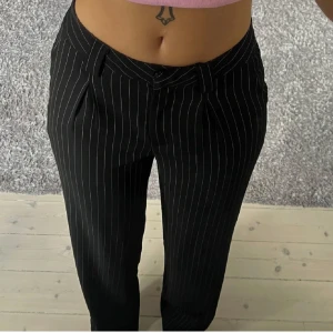 Svarta randiga kostymbyxor - Snygga svarta kostymbyxor med vita ränder. 