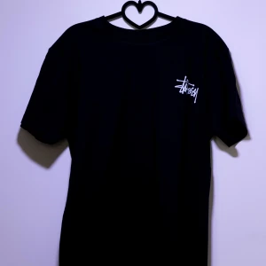 Stüssy T-shirt / Stussy T-shirt - Helt ny Stüssy T-shirt / Stussy T-shirt med vit text på bröstet och ryggen. Perfekt för en snygg look.