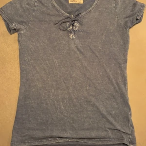 Blå t-shirt från Hollister knytning - fin blå tröja från hollister, har knytning som kan dras åt. Inte använd så mycket, men är köpt ungefär 2015.