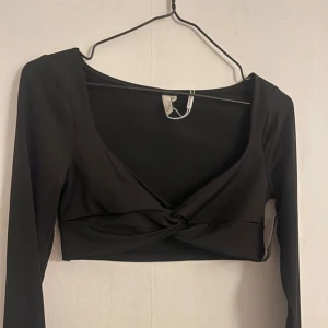 Svart croppad topp med knyt - Topp från Nelly 